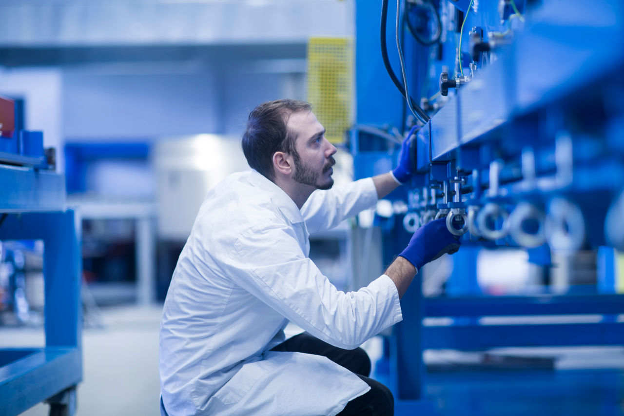 Foto de homem inspecionando máquina industrial.